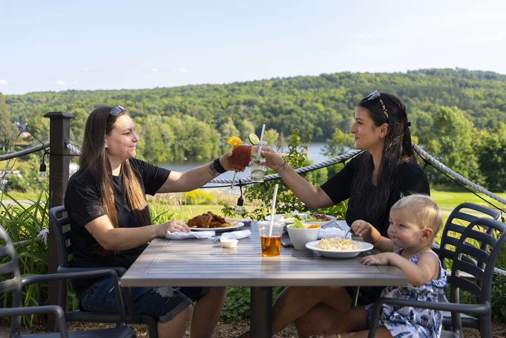 Two parents and their daughter enjoying lunch on the patio