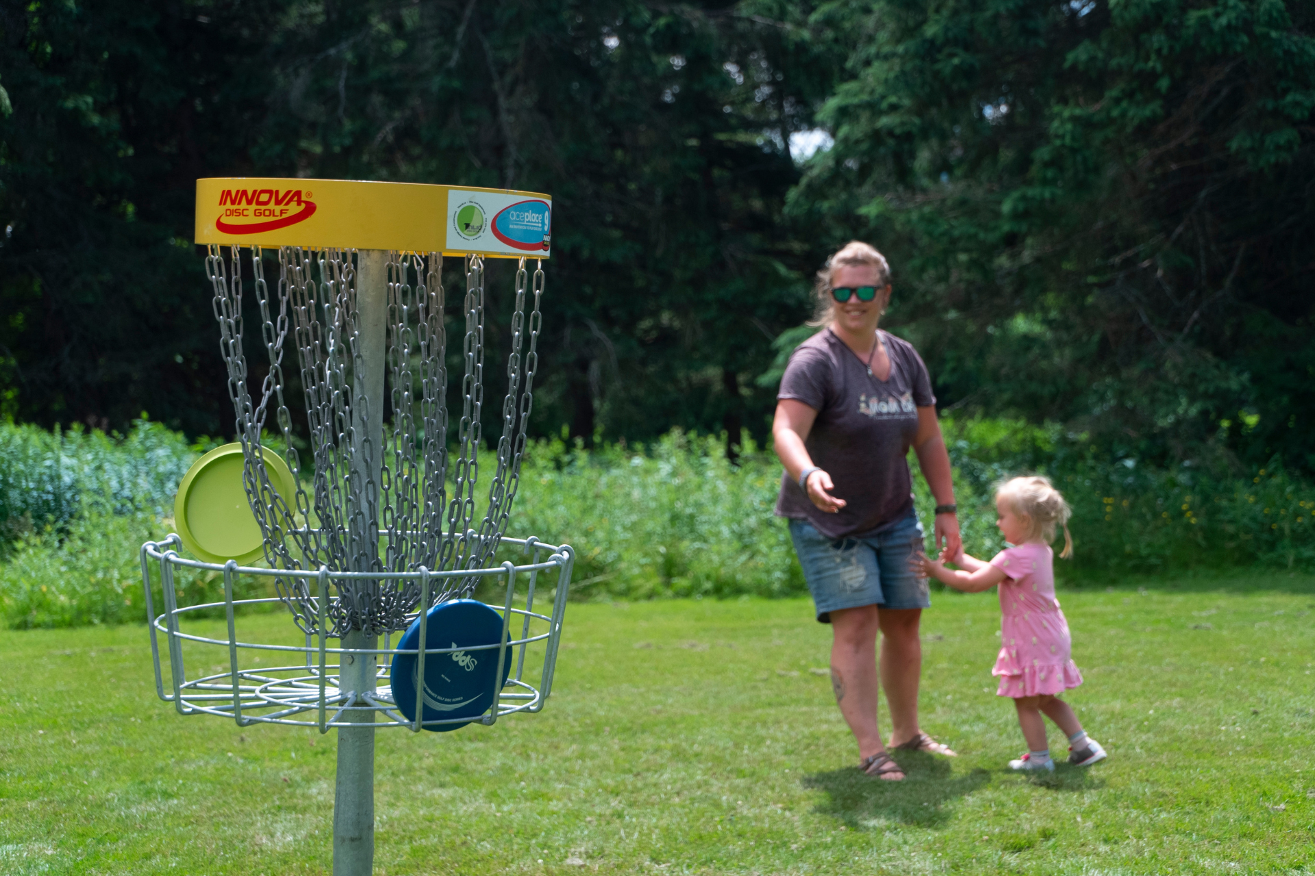 Woman holding childs hand after throwing frisbee